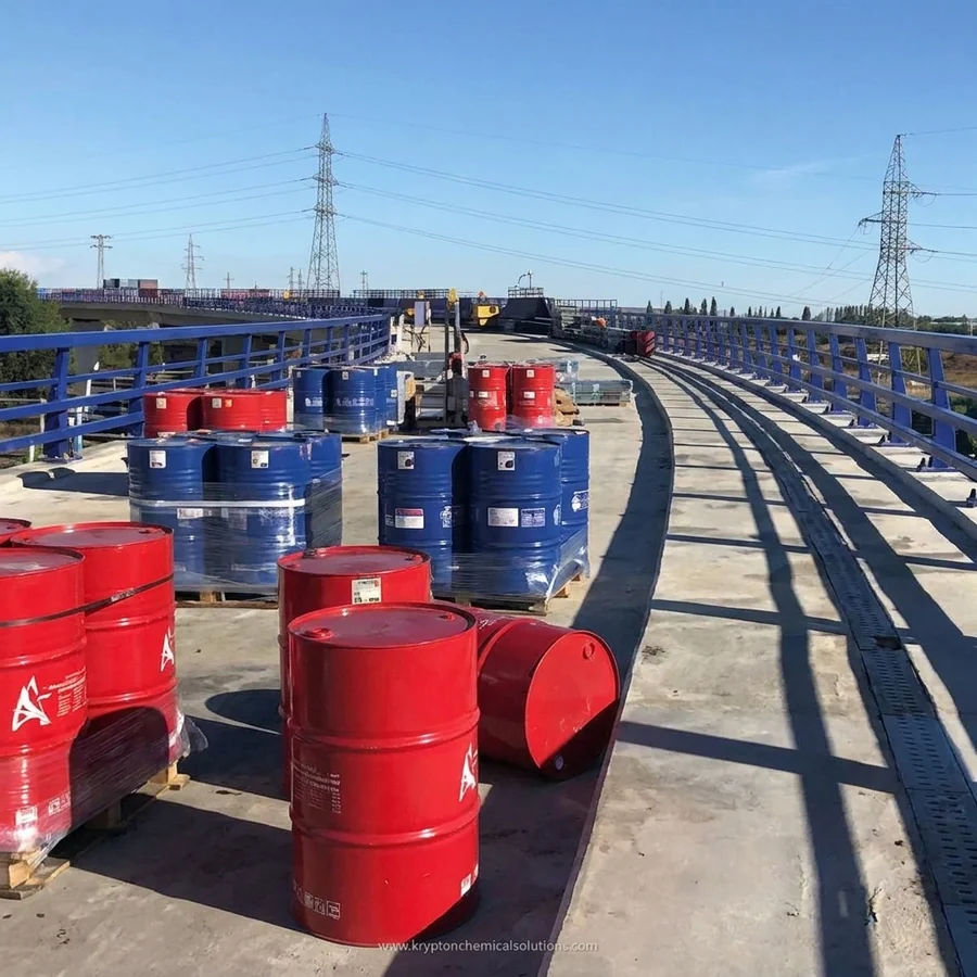 Red and blue Krypton Chemical drums staged on the Colmenar M-40 bridge deck during Impermax Polyurea H Flex waterproofing