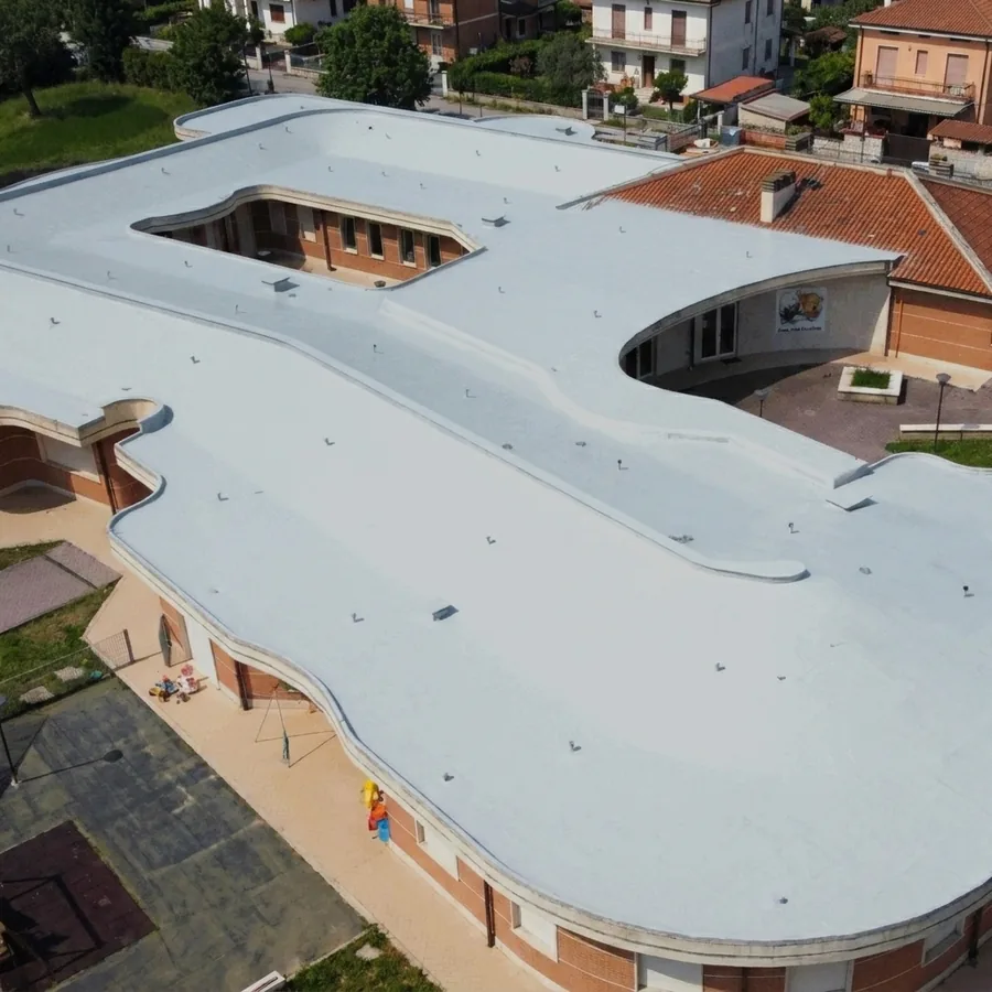 Aerial view of a curvilinear school roof coated in a seamless light-grey Impermax Polyurea H Supreme membrane