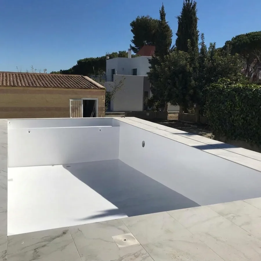 Empty rectangular rooftop pool with a seamless white waterproof coating and marble-effect deck tiles