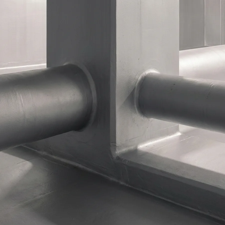 Grey seamless Impermax 2K M coating around a pillar and pipe penetrations, airtight coved joints