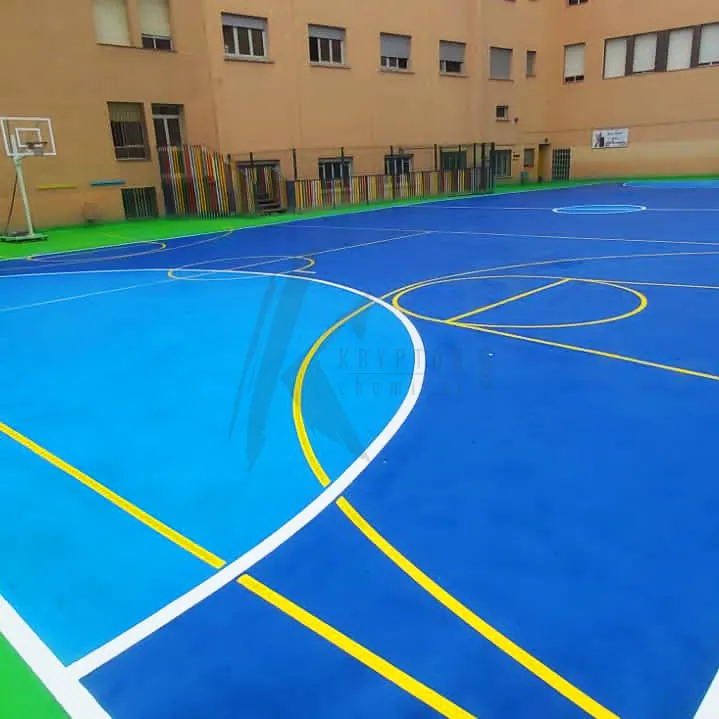 Blue court with a green surround between the school buildings