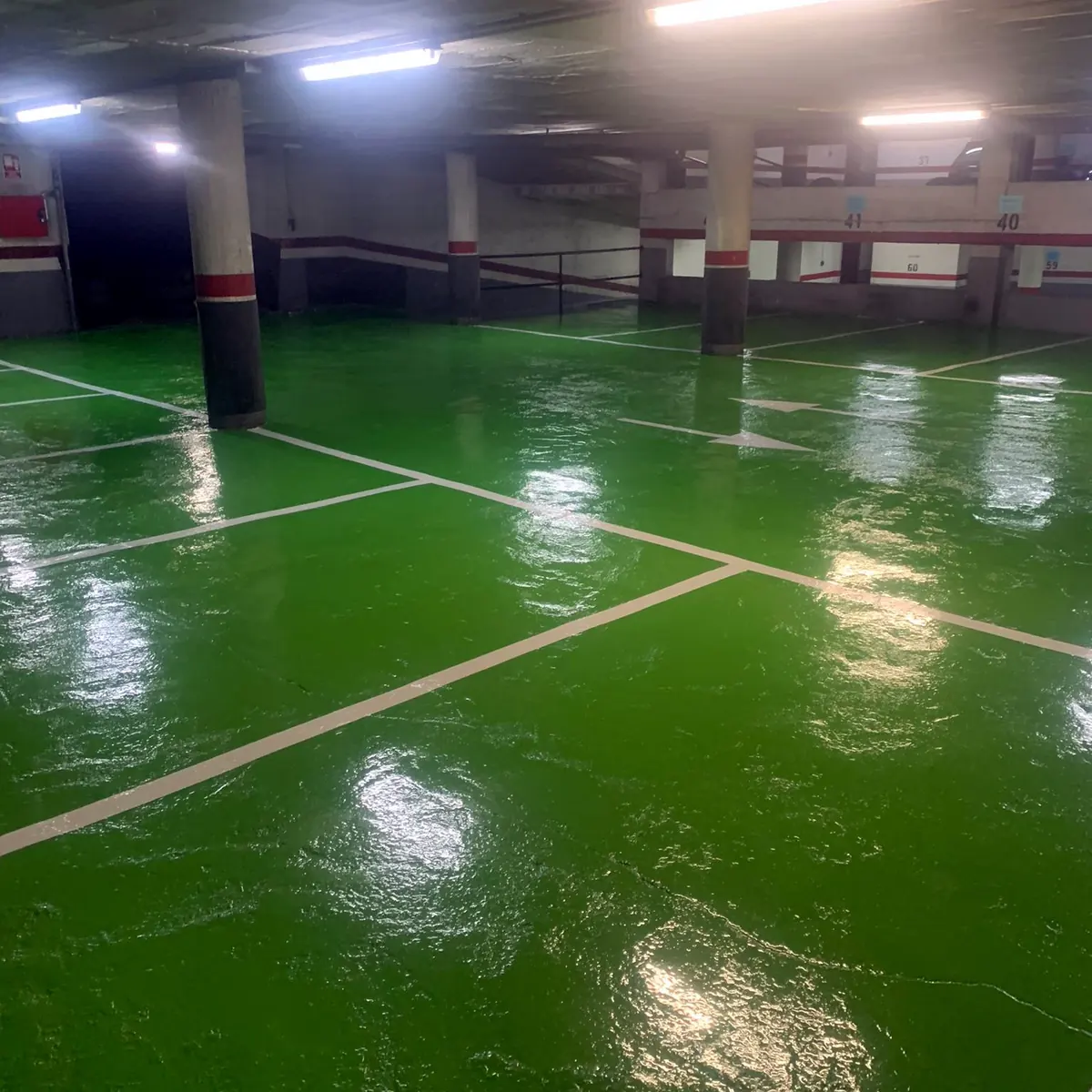 White bay lines on the glossy green epoxy floor, Puigcerdà car park White bay lines on the glossy green epoxy floor, Puigcerdà car park