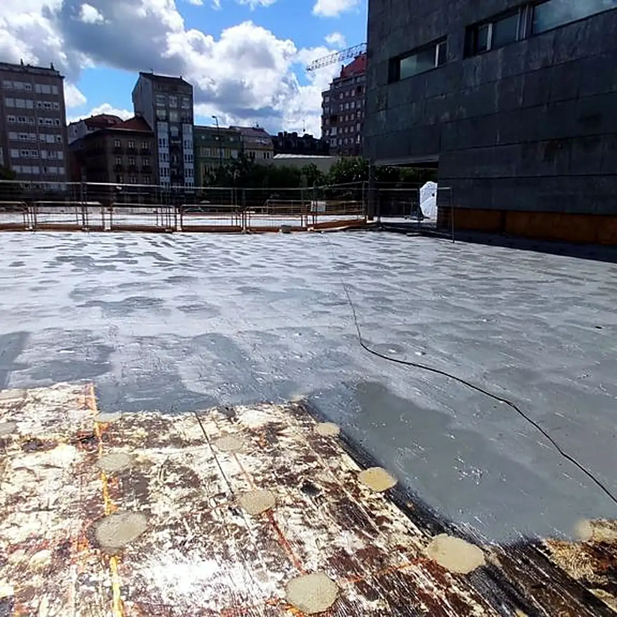 Old bitumen sheet with patches beside the new grey coat on the auditorium roof, Vilagarcía Old bitumen sheet with patches beside the new grey coat on the auditorium roof, Vilagarcía