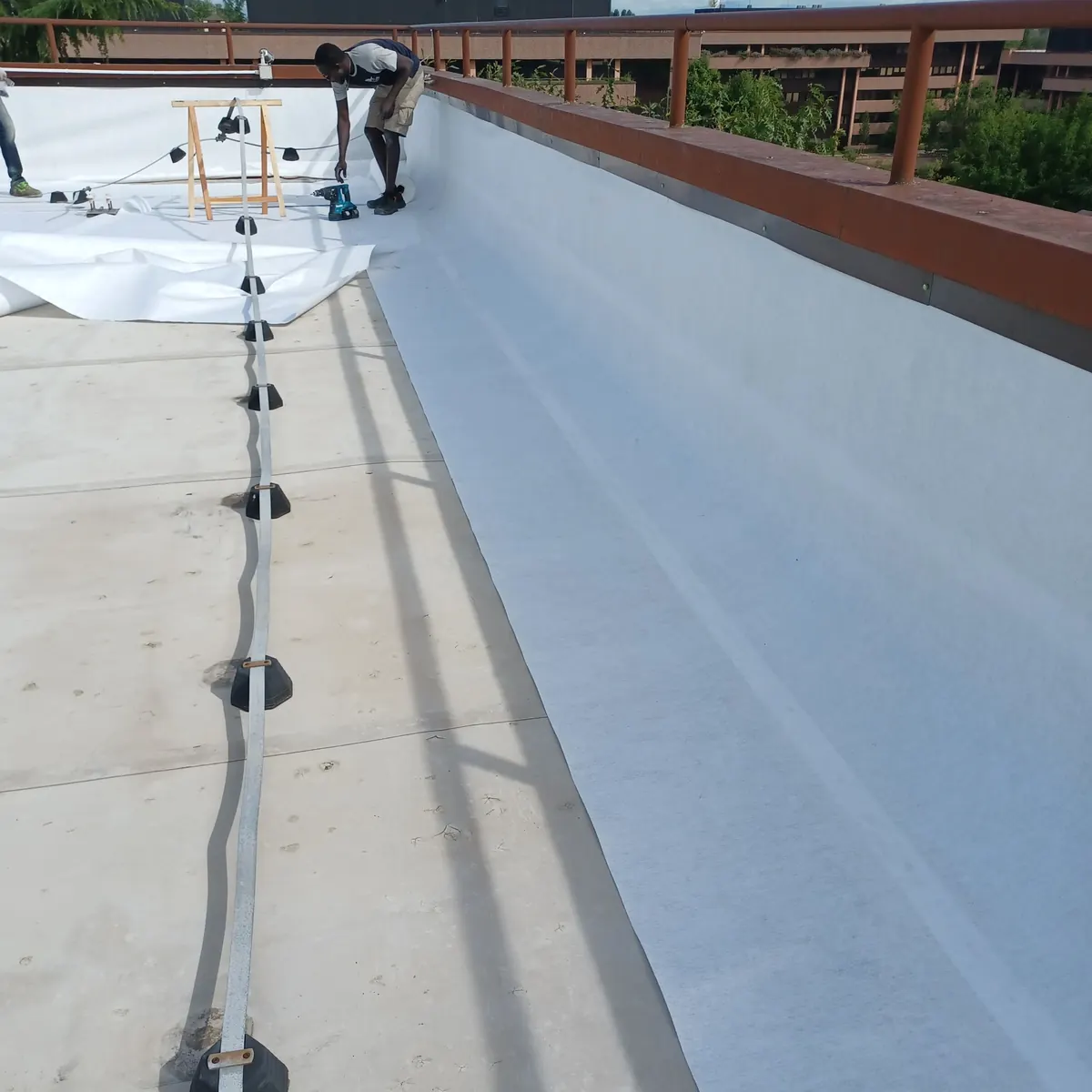 White strip laid on aged roof before full spray, Milan