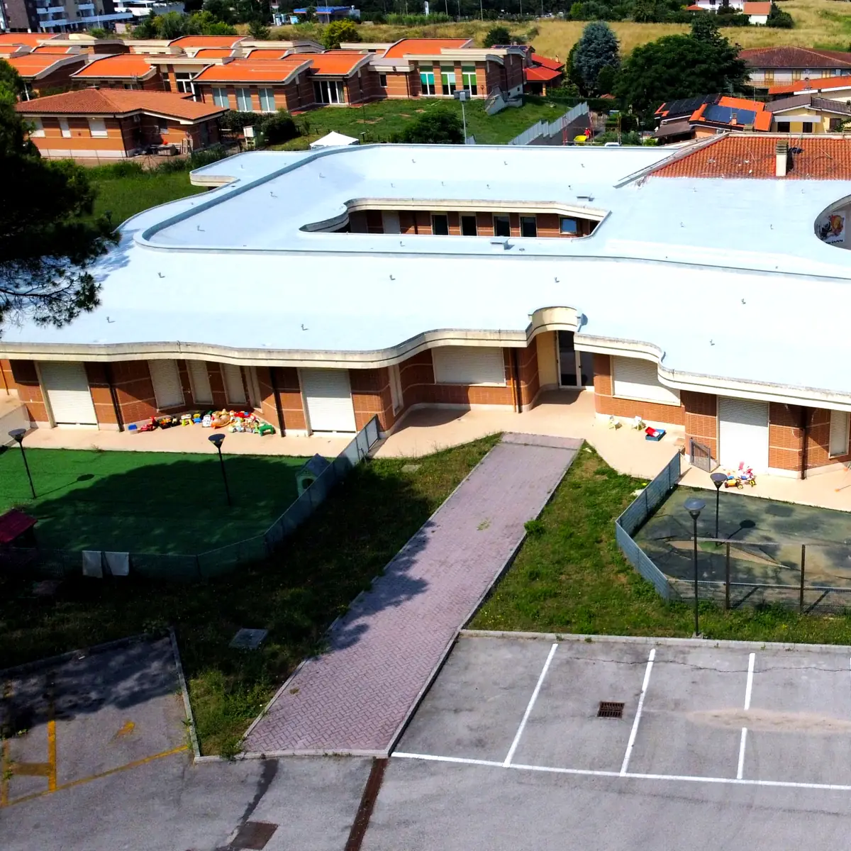Nursery school wing with its renewed white roof and garden in Rome