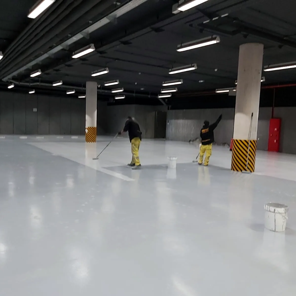Two workers rolling the coat in the open hall