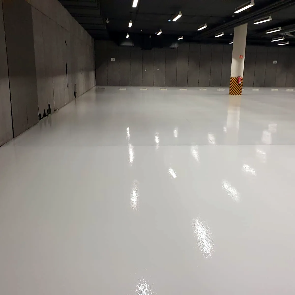 Long stretch of the light floor beside the hall wall