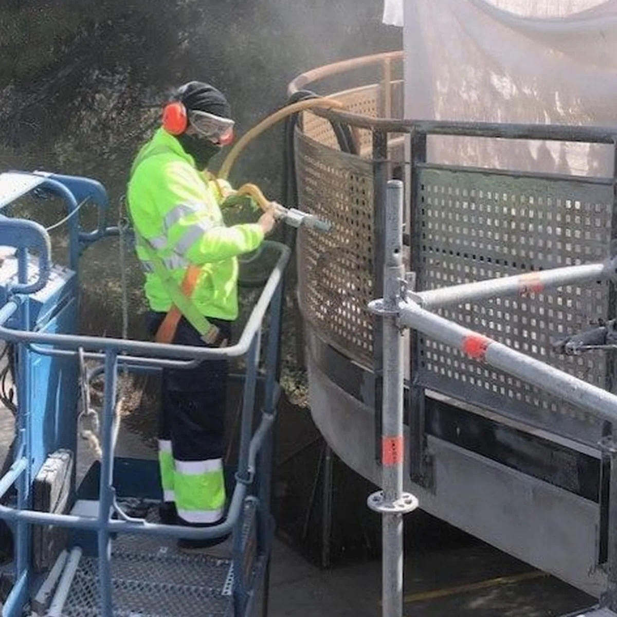 Applicator spraying the railing from a lift platform, Castelldefels