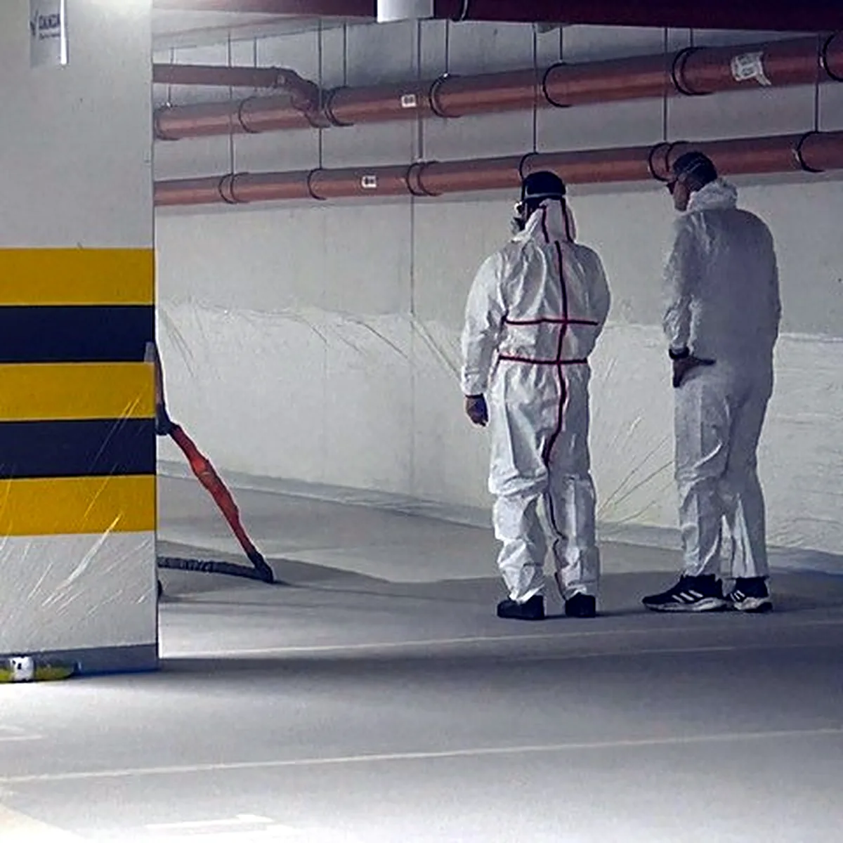 Two applicators in white suits on the finished car park polyurea flooring in Kraków