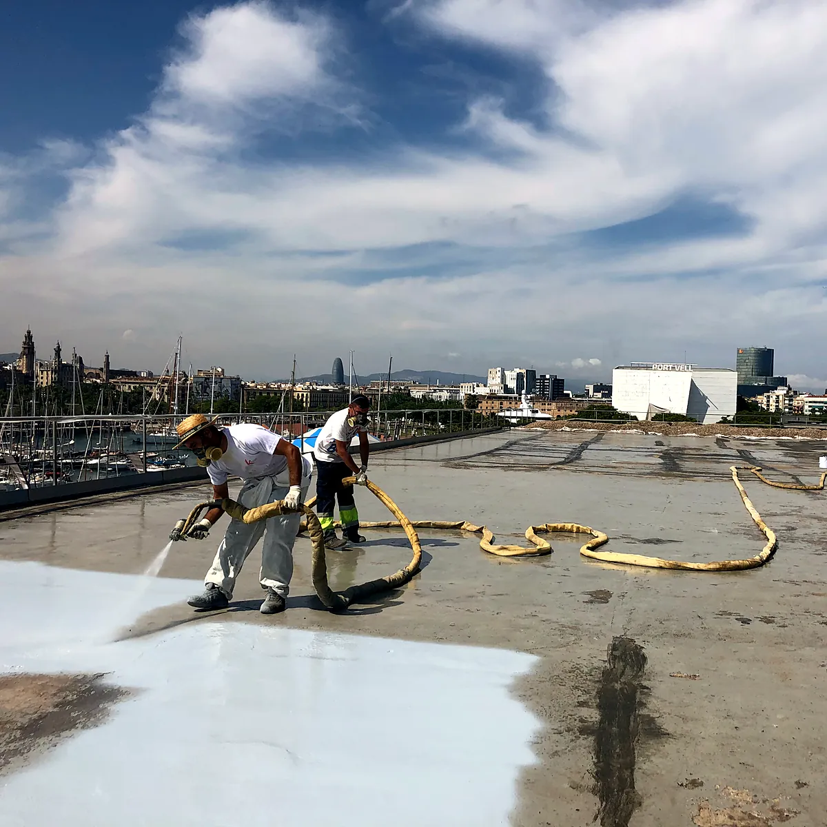 La manguera caliente cruzando la cubierta. Aplicadores con la manguera caliente en la cubierta de Maremagnum.