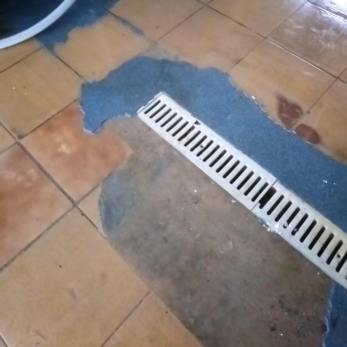 Drain grate with preparation layer on old tiles, Ciutadella