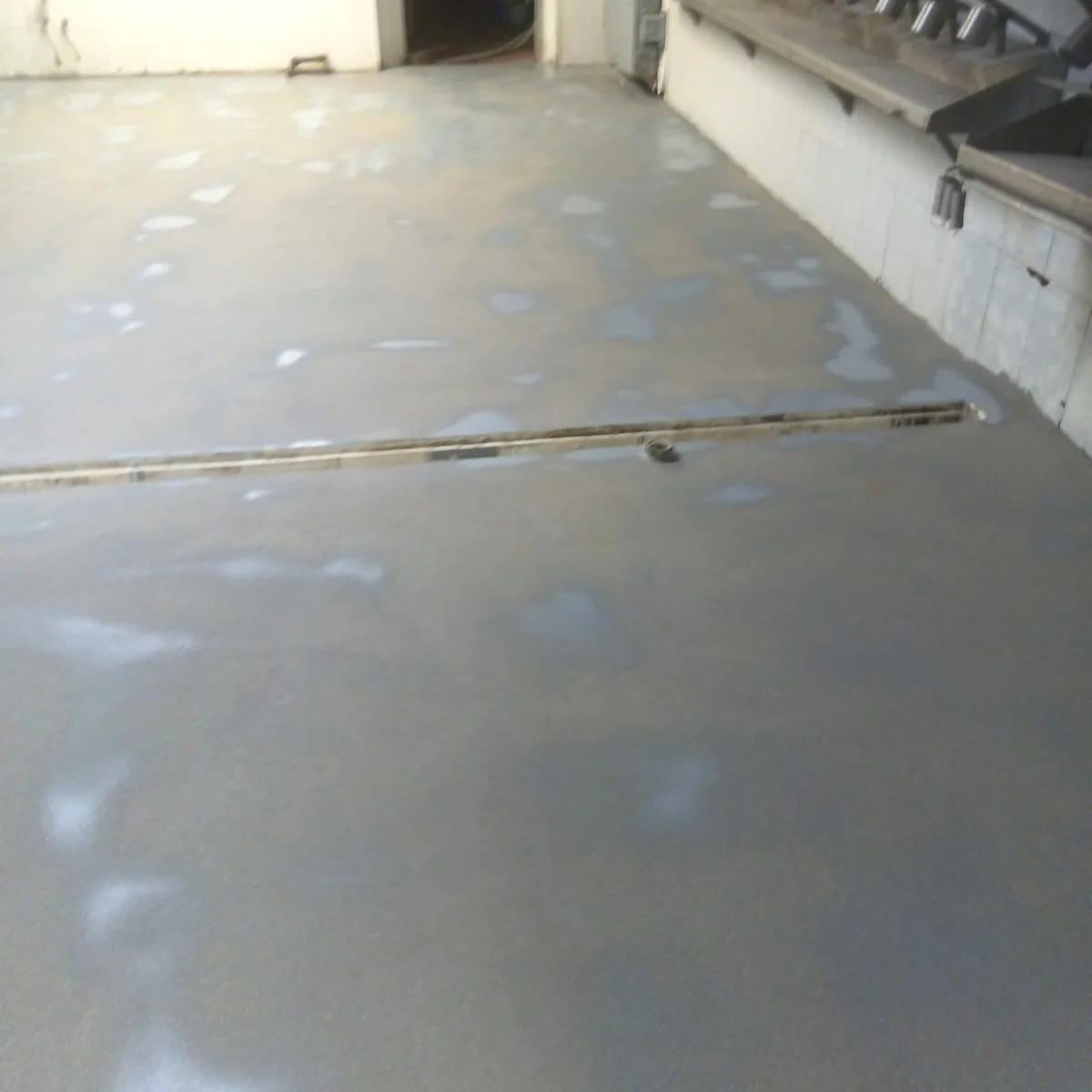 Coated floor with drain lines along the wall, Ciutadella