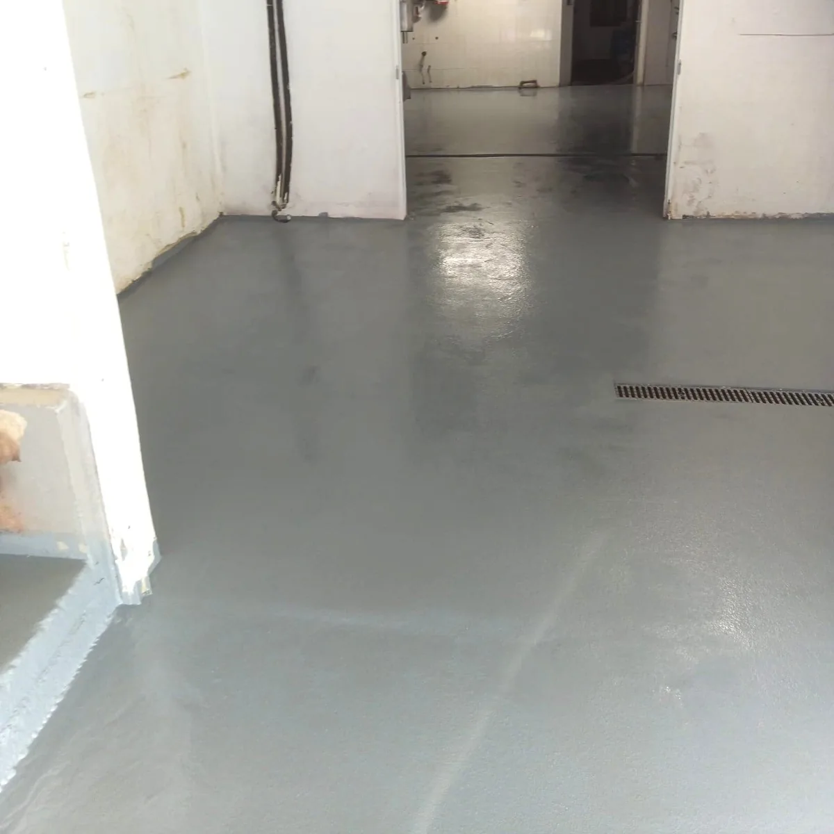 Glossy grey epoxy floor along a corridor, Menorca dairy