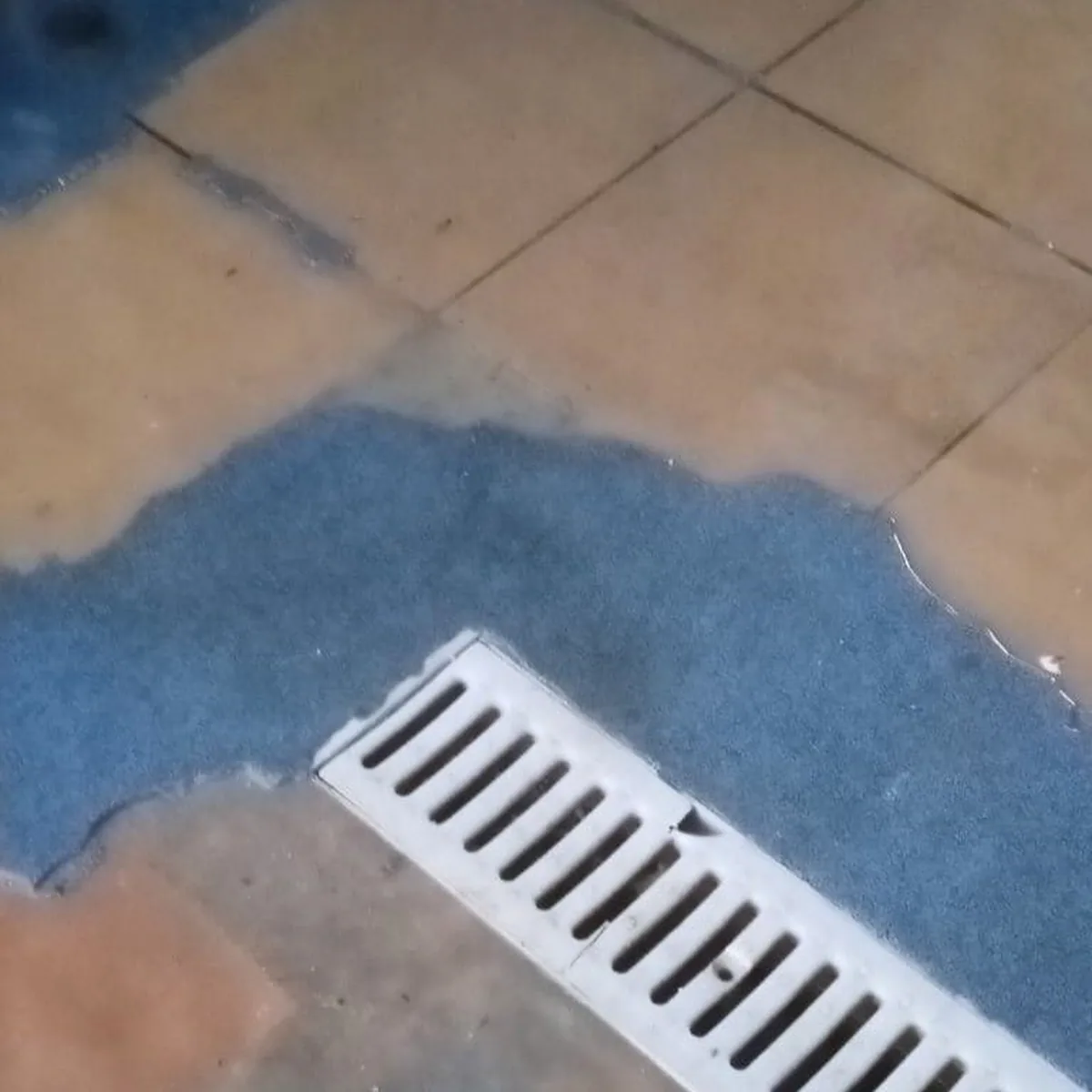 Tecnocem patch over old tiles at a floor drain, Ciutadella