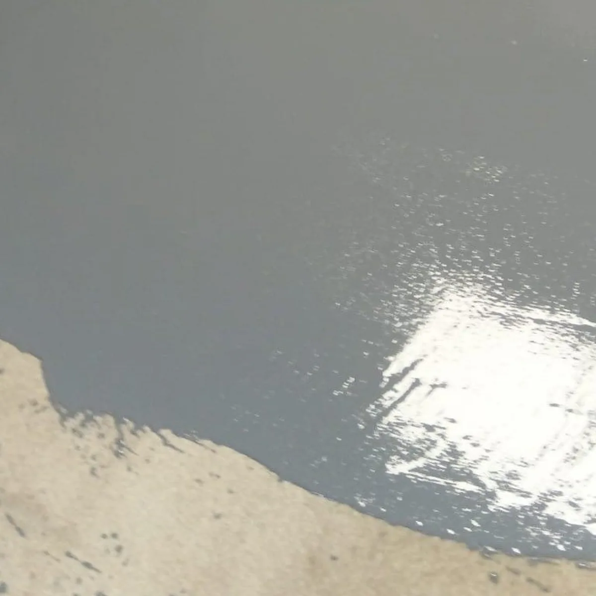 Wet grey EP Coat 100 spreading over old tiles, Menorca