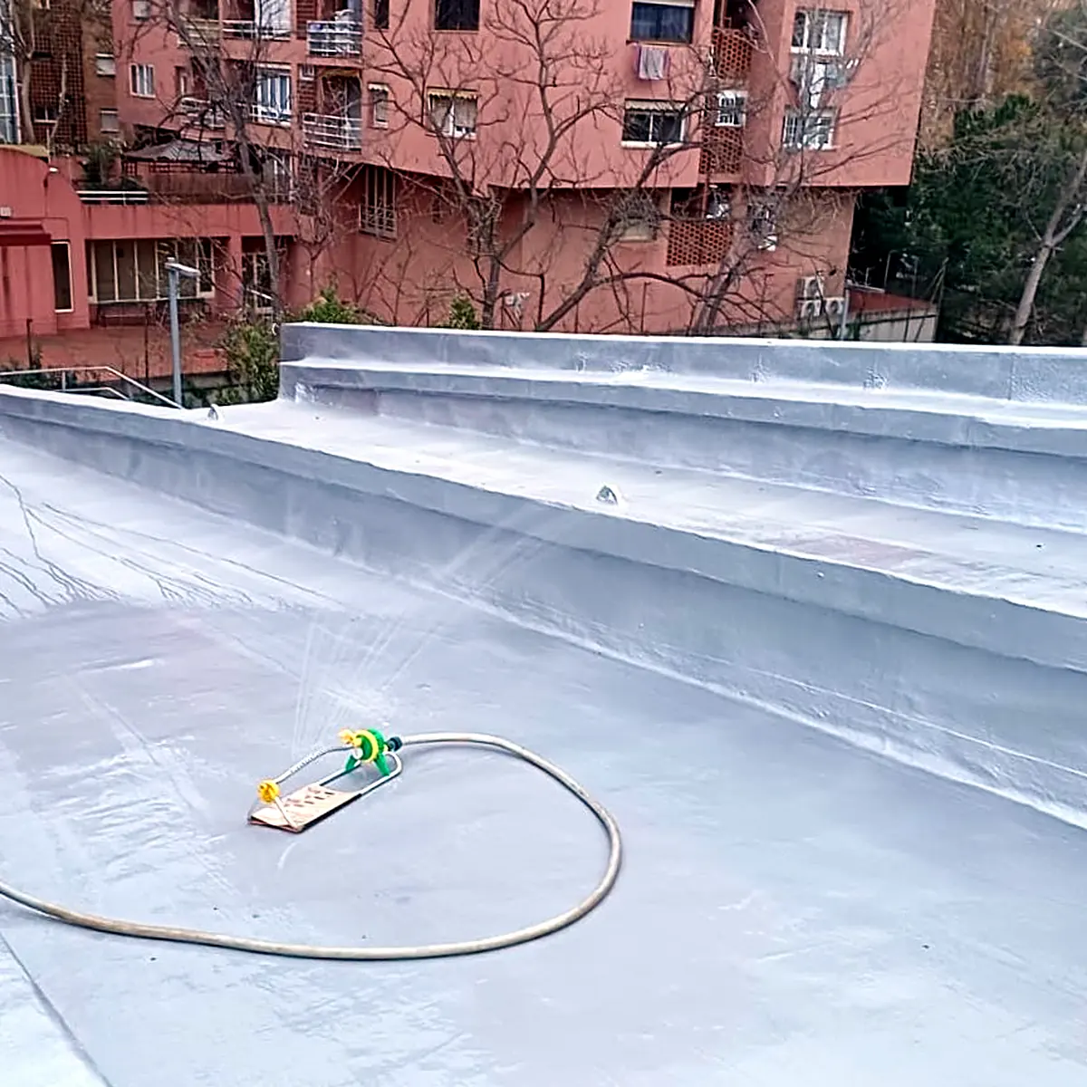 Garden sprinkler wetting the finished roof membrane, Sants