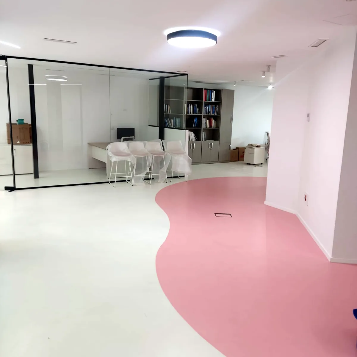 Pink floor band running past a glass office in the Alicante dental clinic Pink floor band running past a glass office in the Alicante dental clinic