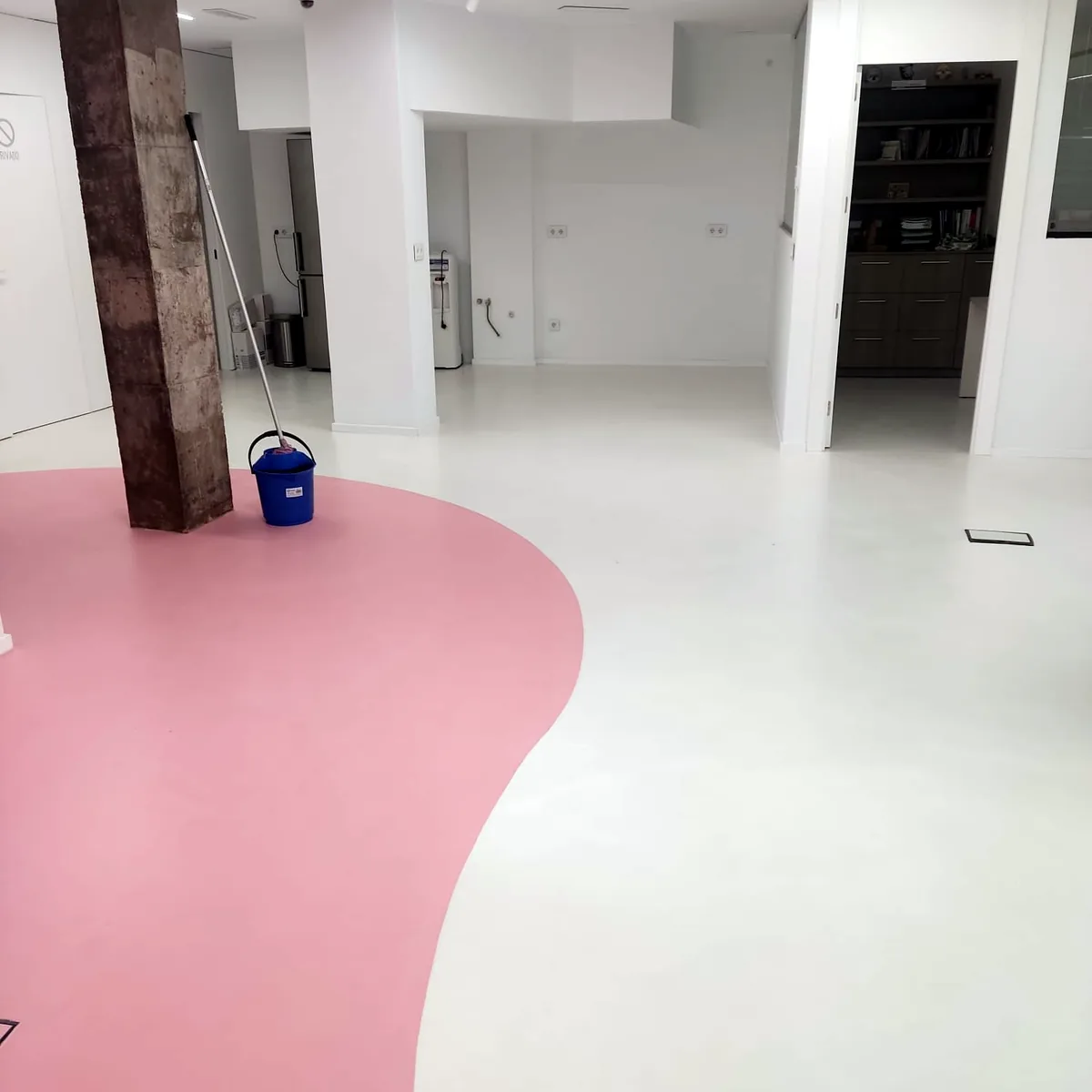 Curving pink band in a white polyurethane floor beside a pillar, Alicante dental clinic Curving pink band in a white polyurethane floor beside a pillar, Alicante dental clinic