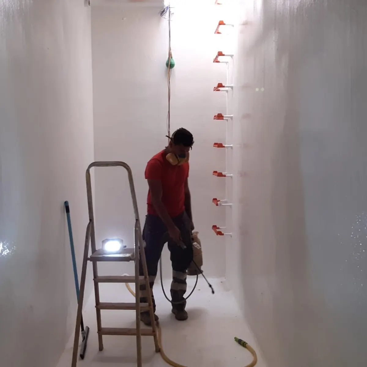 Worker coating lower tank wall in respirator, Tortosa