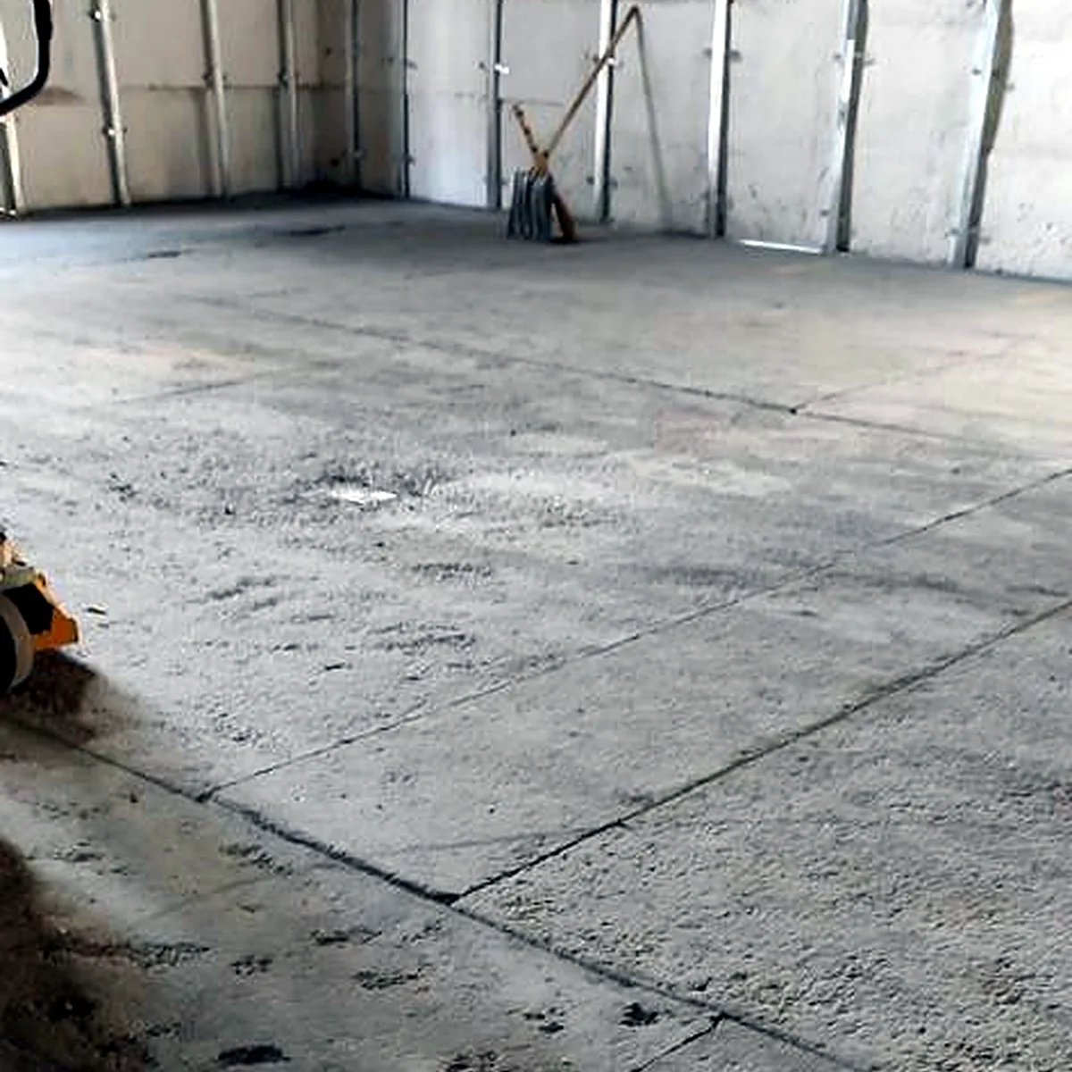 Old slab with a broom and tools by the wall, drinks warehouse in Ukraine