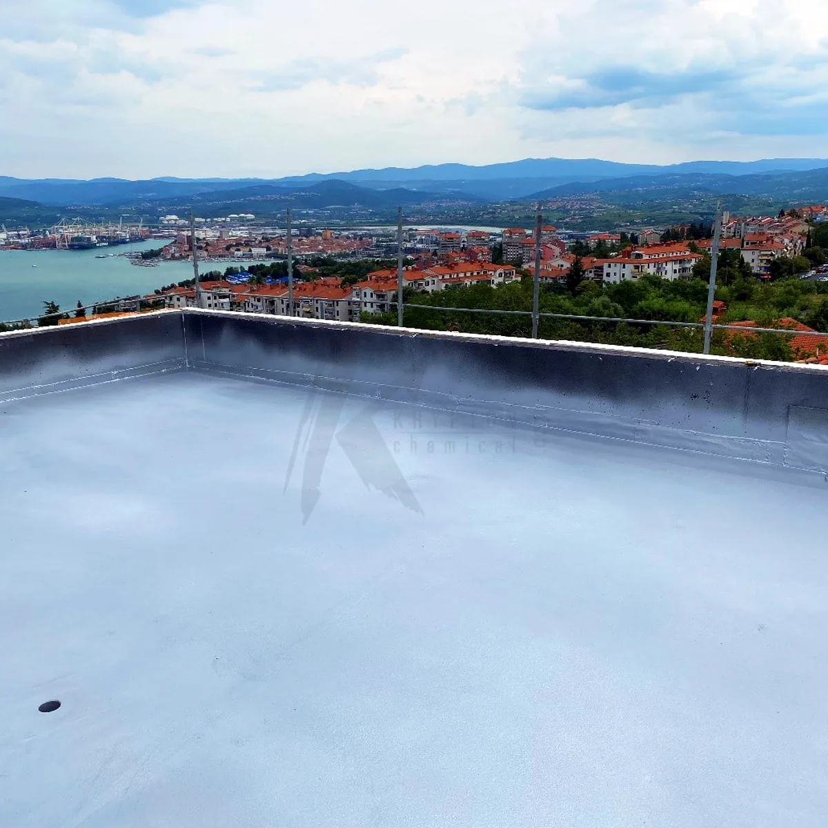 Aluminium-coloured polyurea membrane on a flat roof above the town and bay of Koper, Slovenia