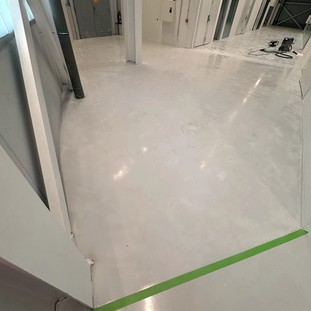 Corridor floor with green tape along the wall edge