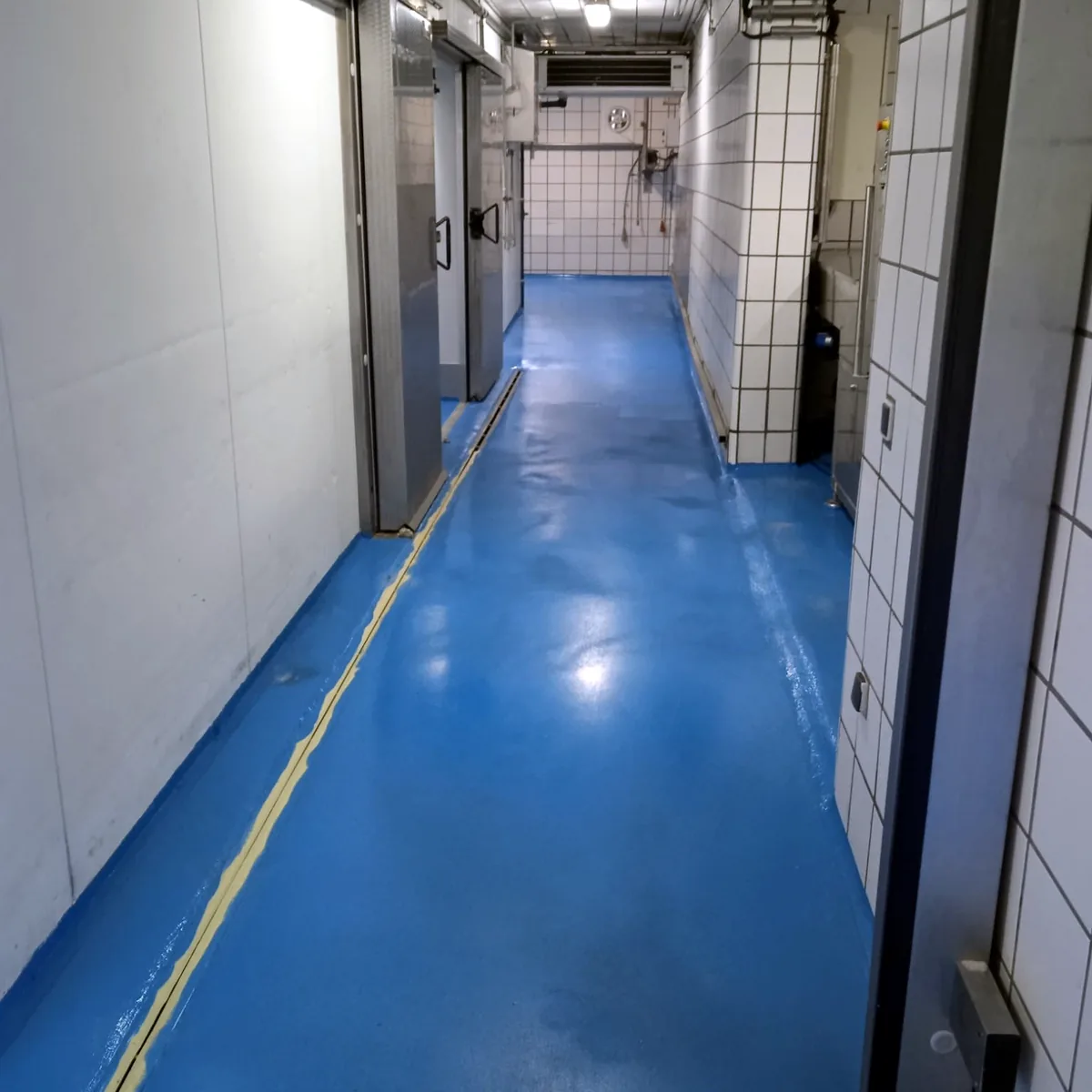 Long corridor with a blue anti-slip floor between white walls, Prats de Lluçanès Long corridor with a blue anti-slip floor between white walls, Prats de Lluçanès