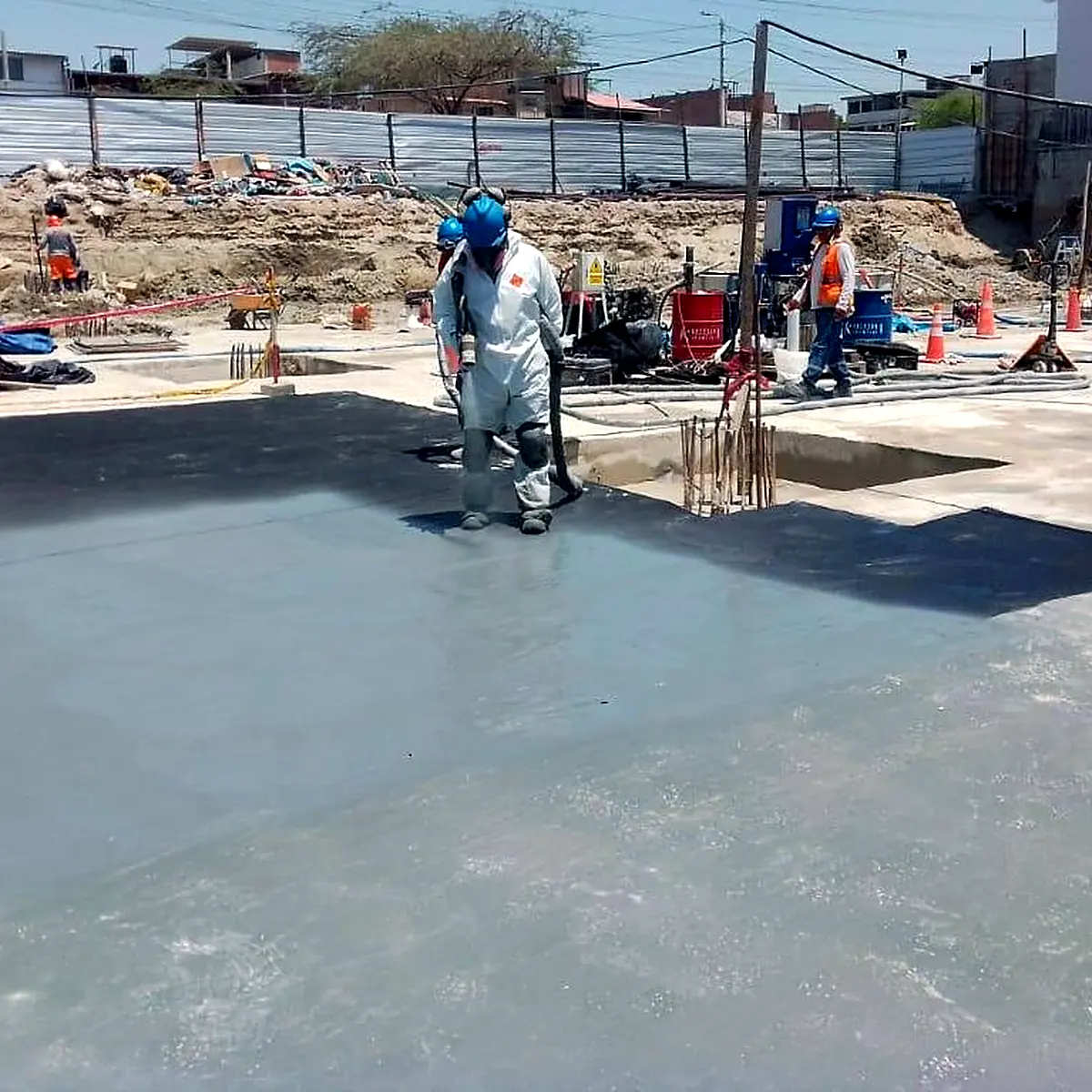 Applicator in full protective suit spraying the membrane, Real Plaza Piura
