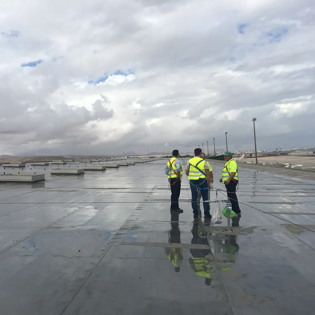 Three workers on the wet finished roof