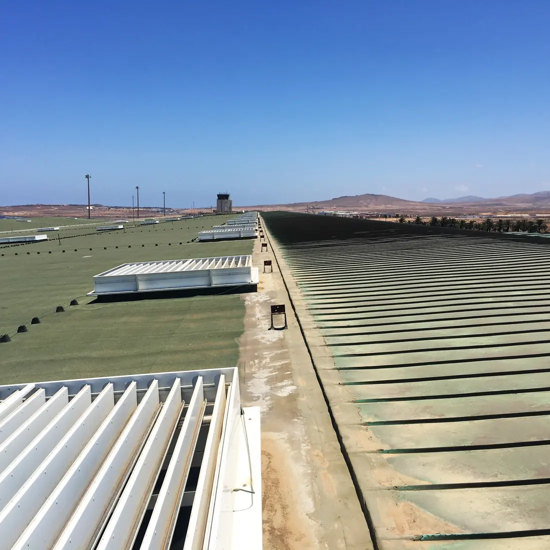 Green membrane beside the metal roof, with the control tower ahead