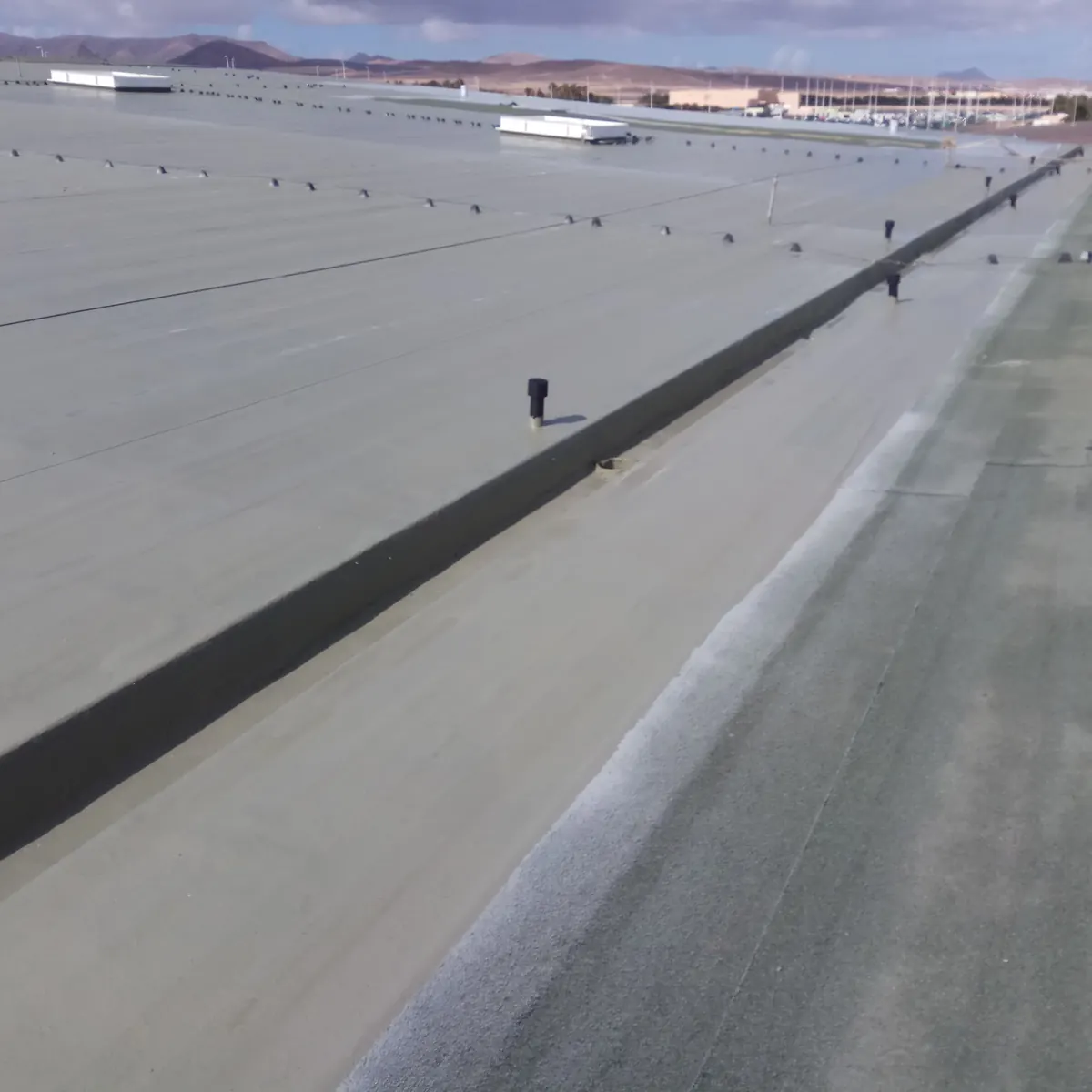 Gutter channel coated grey beside the gravel strip