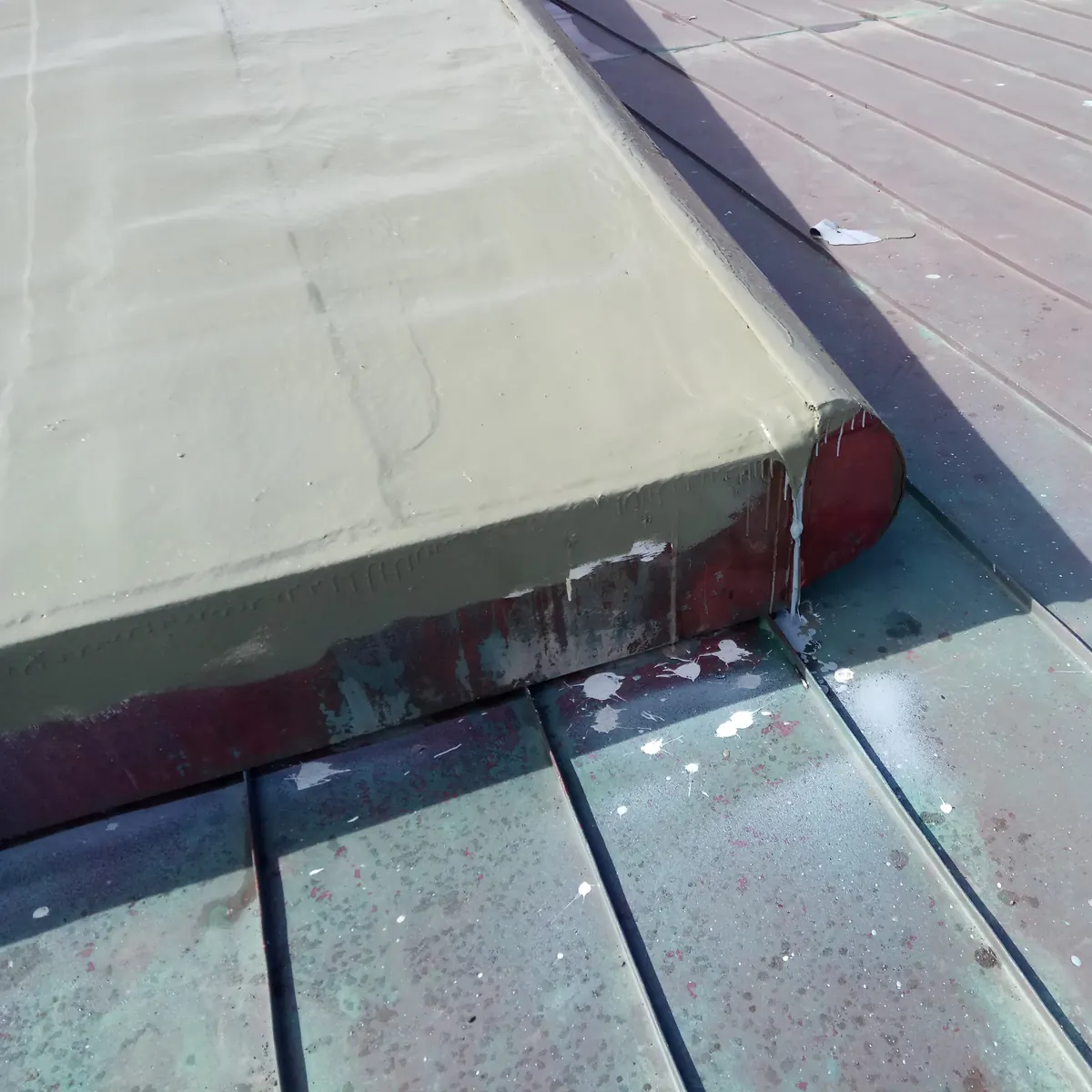 Detail of the grey coat on a rounded curb at the roof edge
