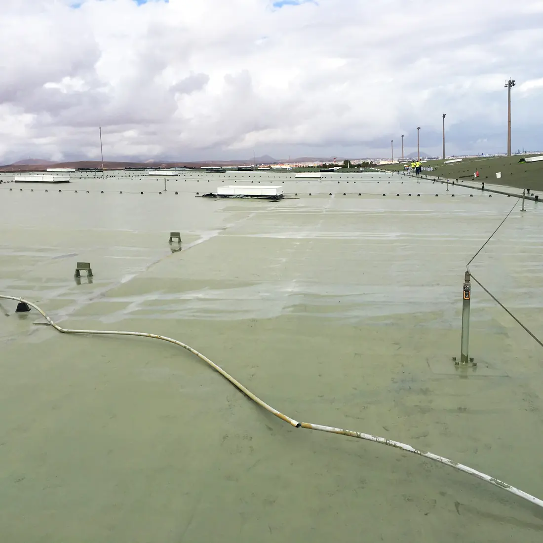 Wet coat with the hose across it and the light masts behind