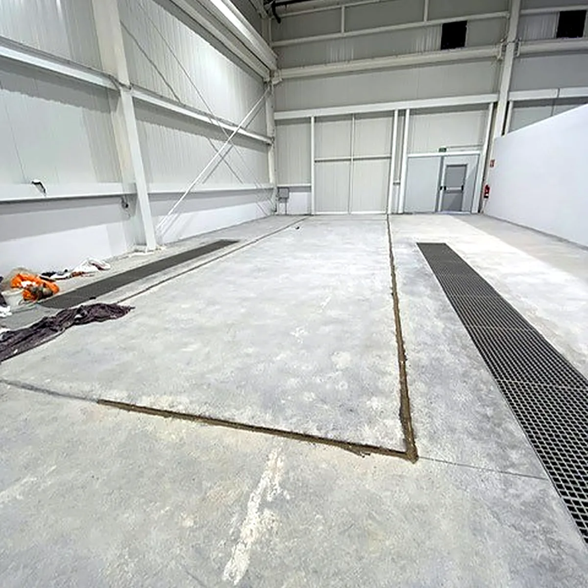 Empty generator hall with a grey, marked slab before the epoxy works, Palma
