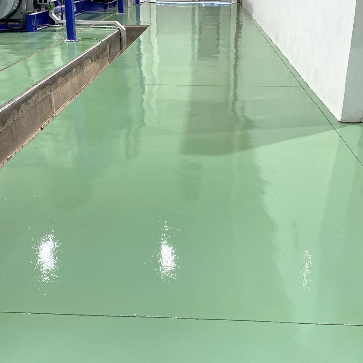 Green RAL 6023 epoxy floor running along the hall wall, Palma airport