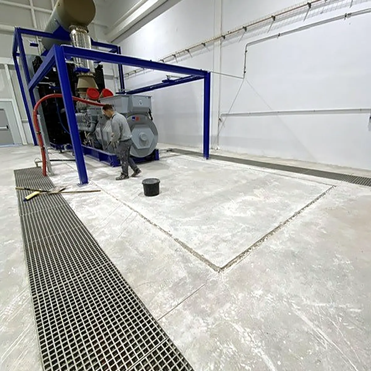 Bare concrete slab and floor gratings in the generator hall before coating, Palma airport
