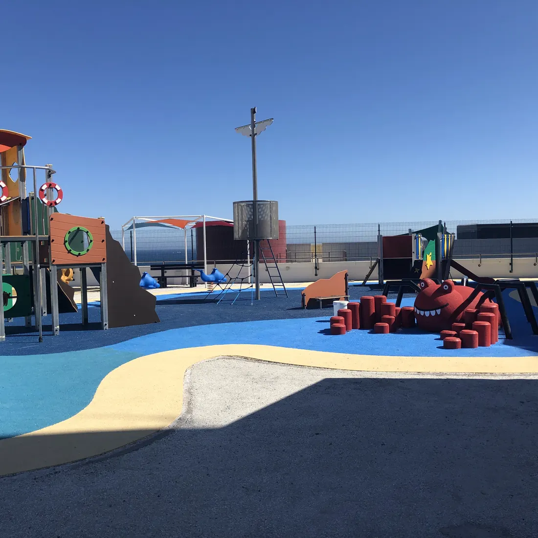 A red play piece on the blue and sand-coloured surface