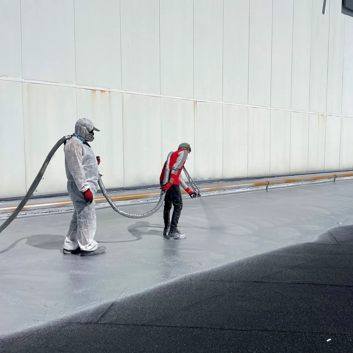 Applicators hot-spraying H Flex Alum on shopping centre roof Applicators hot-spraying H Flex Alum on shopping centre roof