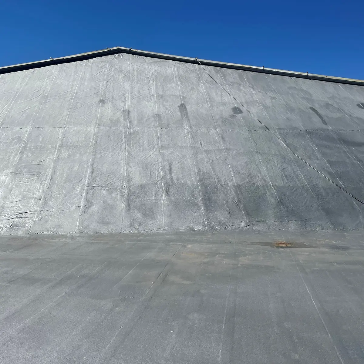 Coated sloped roof face rising from flat field, Paços de Ferreira Coated sloped roof face rising from flat field, Paços de Ferreira