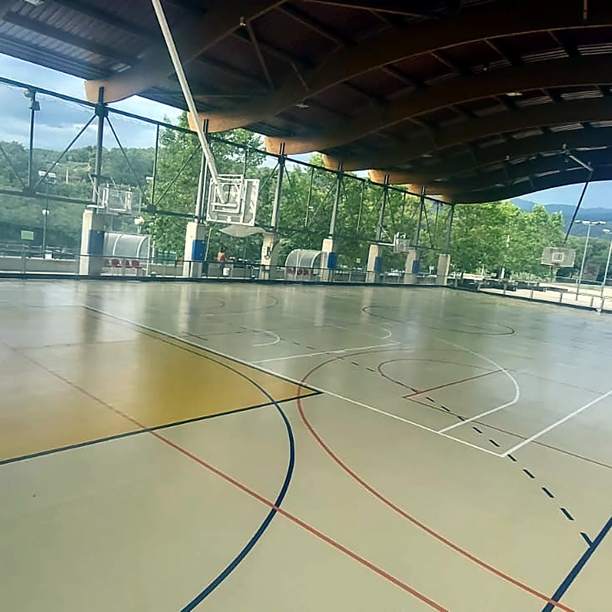 Zona amarilla con líneas curvas rojas y oscuras sobre la pista