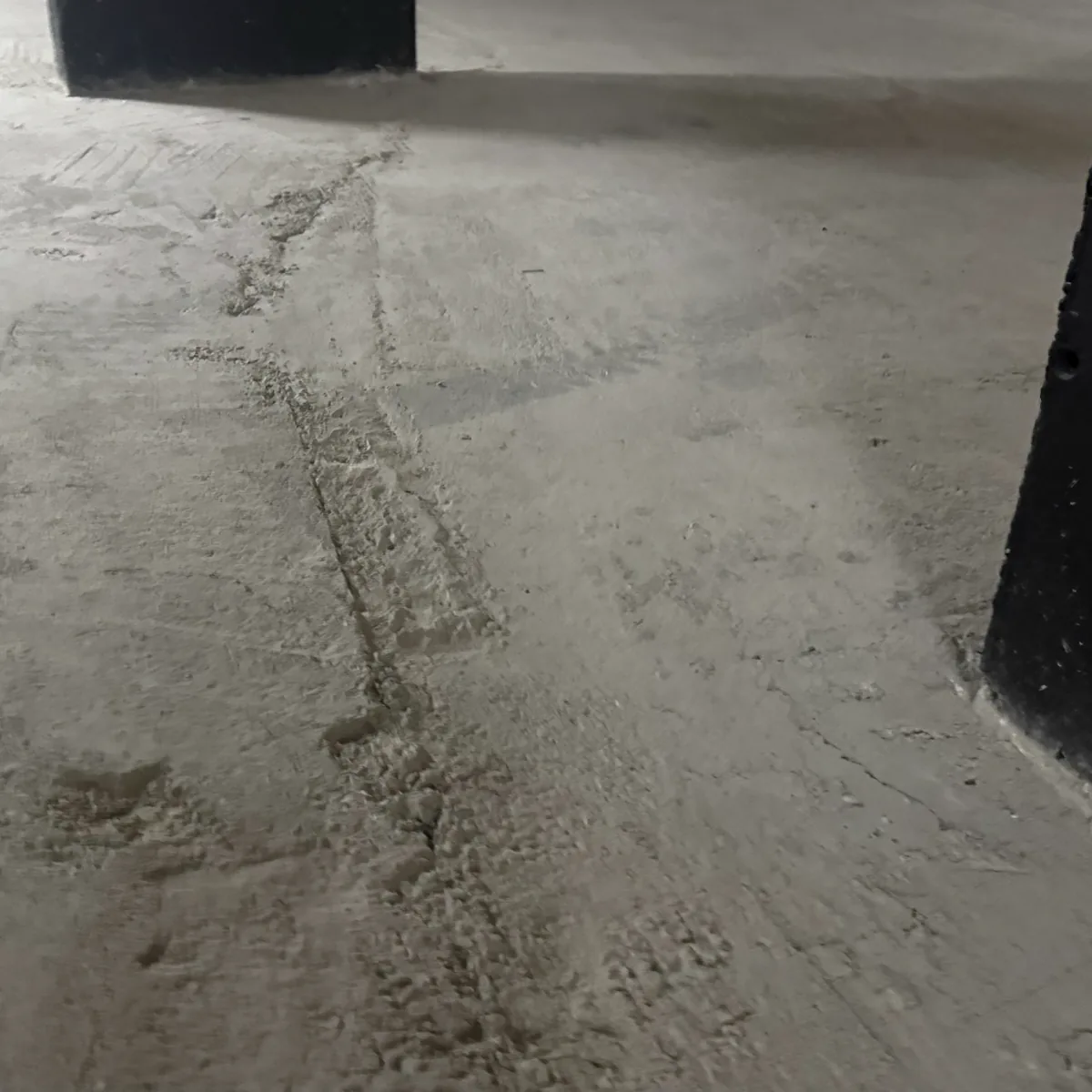 Dusty floor running past a black pillar base Dusty floor running past a black pillar base