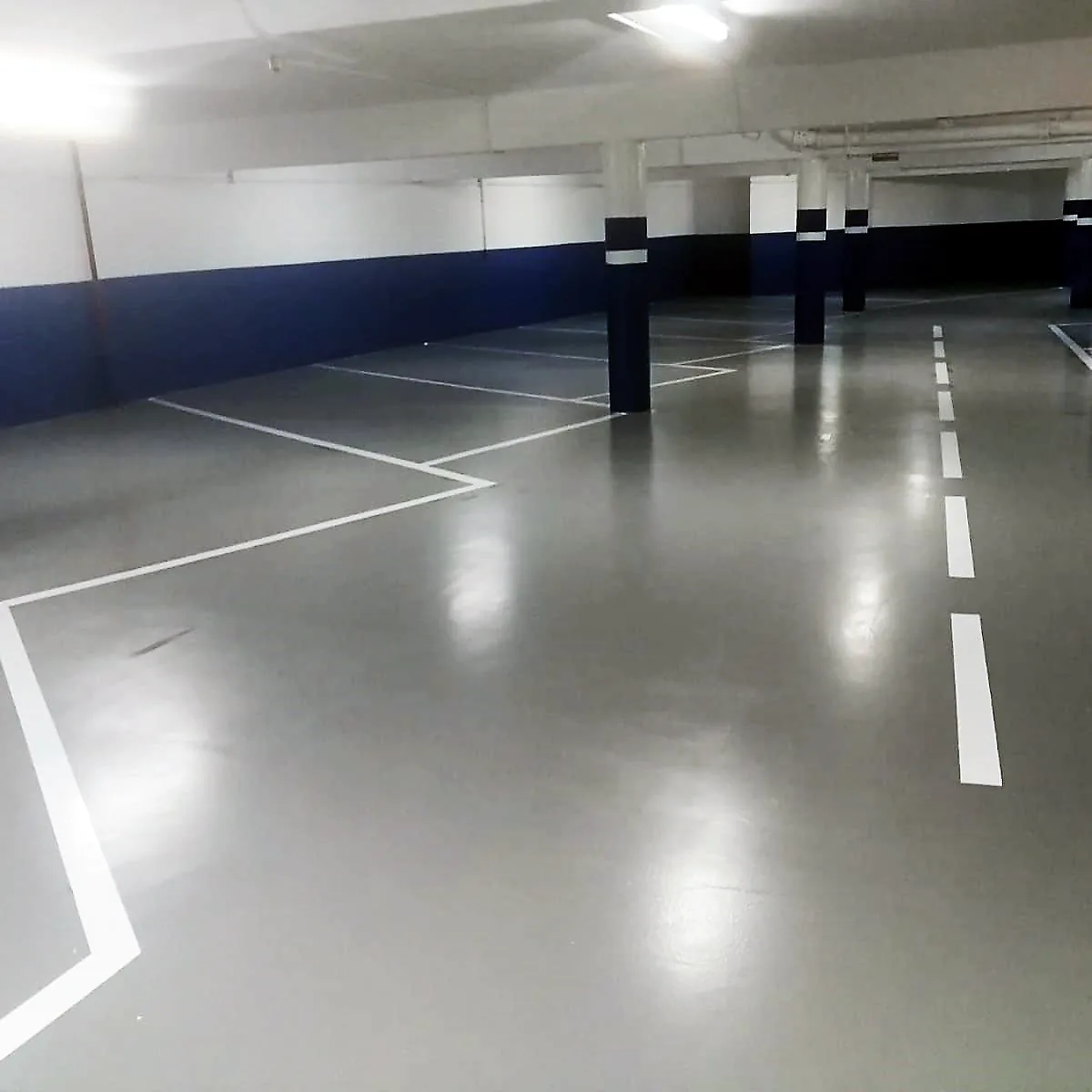 Fresh white bay lines after the hotel garage epoxy coating in Barcelona Fresh white bay lines after the hotel garage epoxy coating in Barcelona