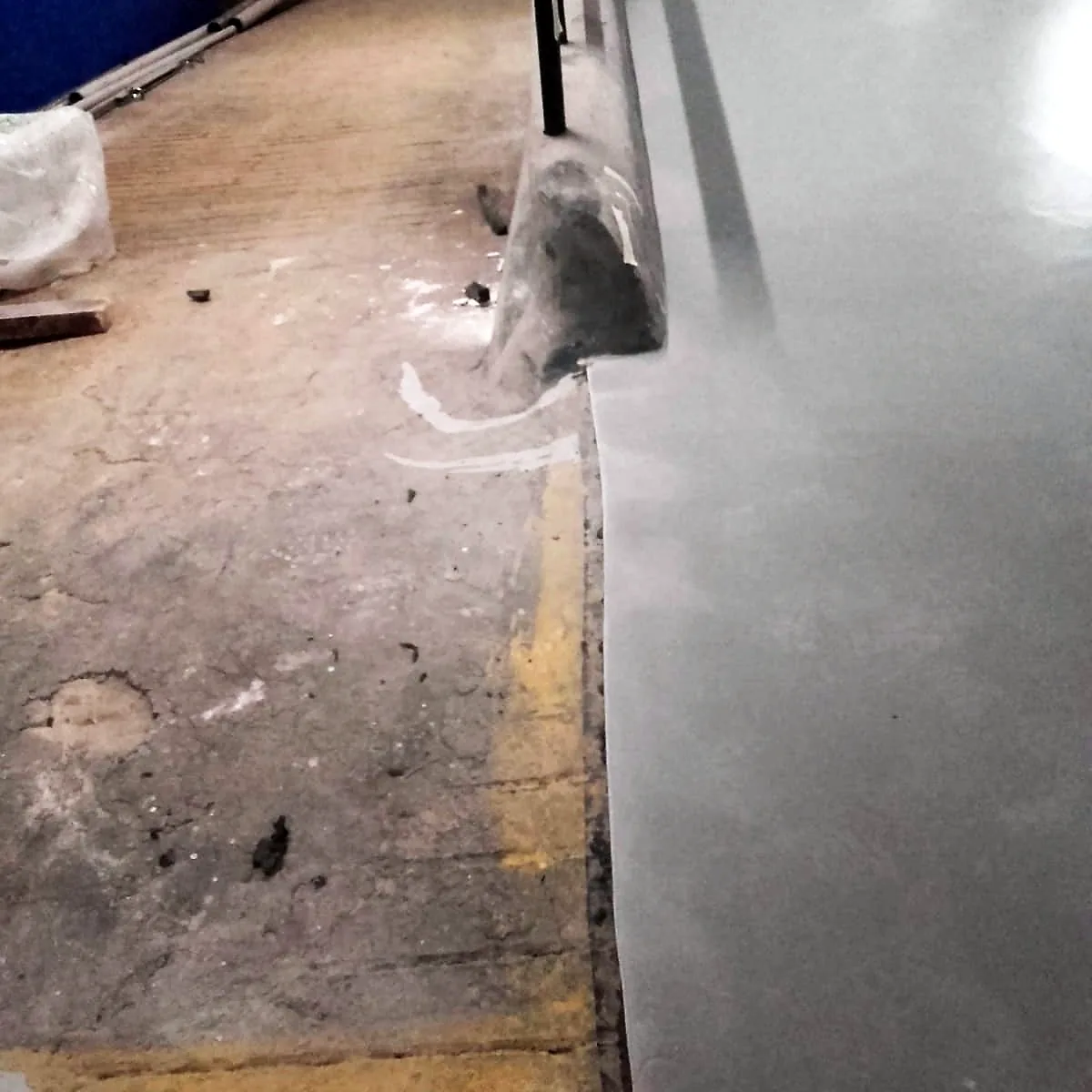 Bare concrete strip and loose debris beside the coated floor Bare concrete strip and loose debris beside the coated floor
