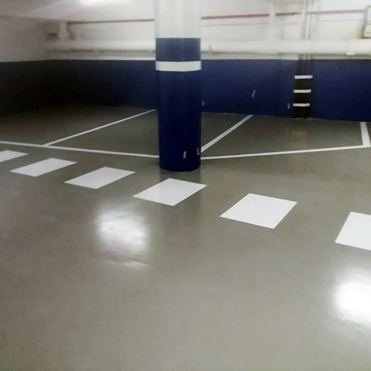 Crossing blocks by a blue pillar, part of the hotel garage epoxy coating in Barcelona Crossing blocks by a blue pillar, part of the hotel garage epoxy coating in Barcelona