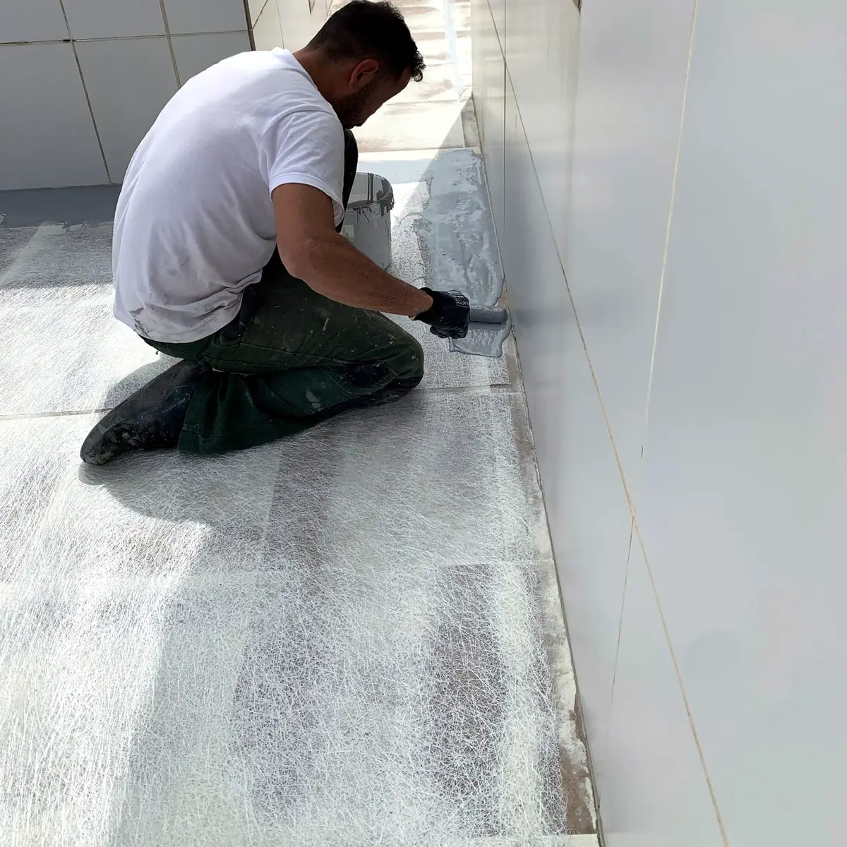 Applicator brushing Impermax QC over Rayston Fiber at the wall joint, Tarragona