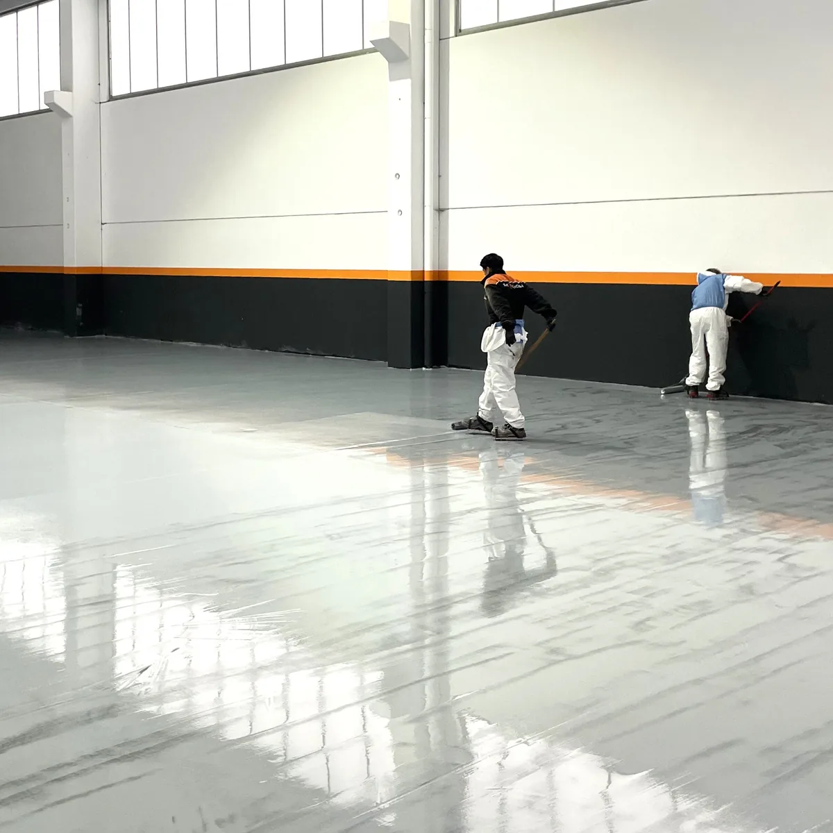 Crew coating the floor along the factory wall base, Galicia Crew coating the floor along the factory wall base, Galicia