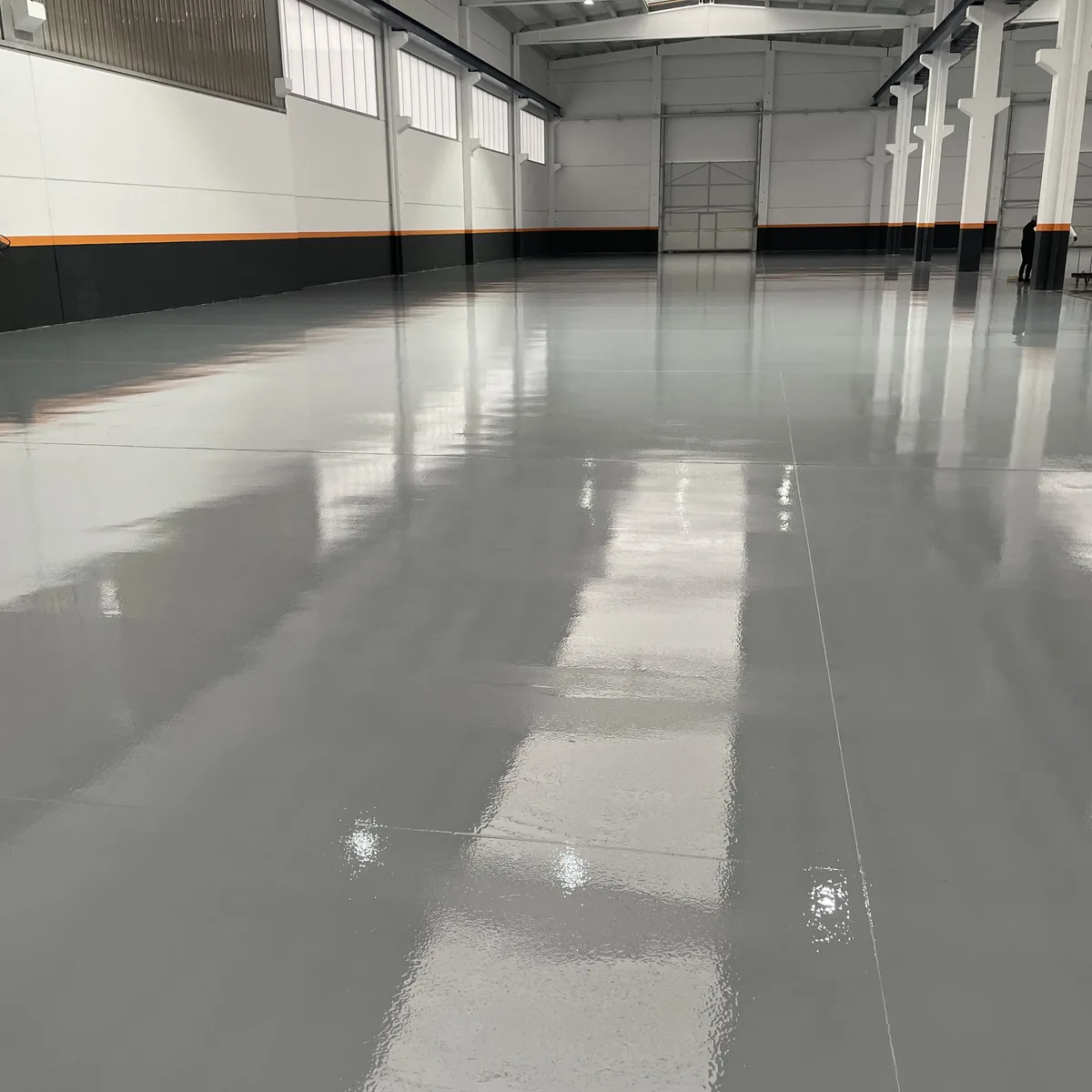 Long glossy grey epoxy aisle in an agricultural machinery factory, Galicia Long glossy grey epoxy aisle in an agricultural machinery factory, Galicia