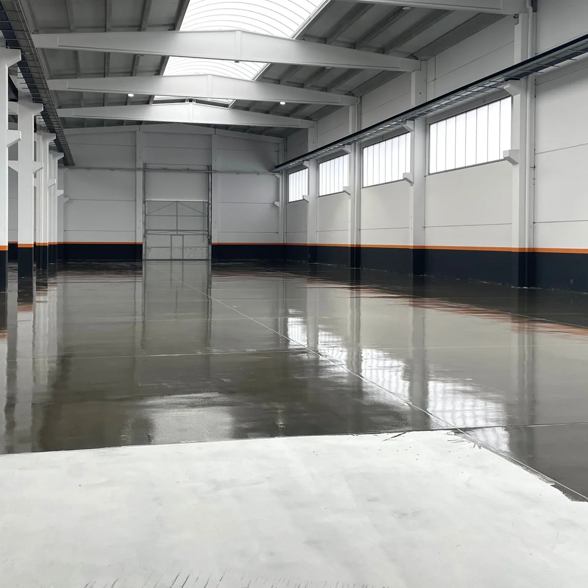 Glossy grey epoxy floor reflecting the factory windows, Galicia Glossy grey epoxy floor reflecting the factory windows, Galicia