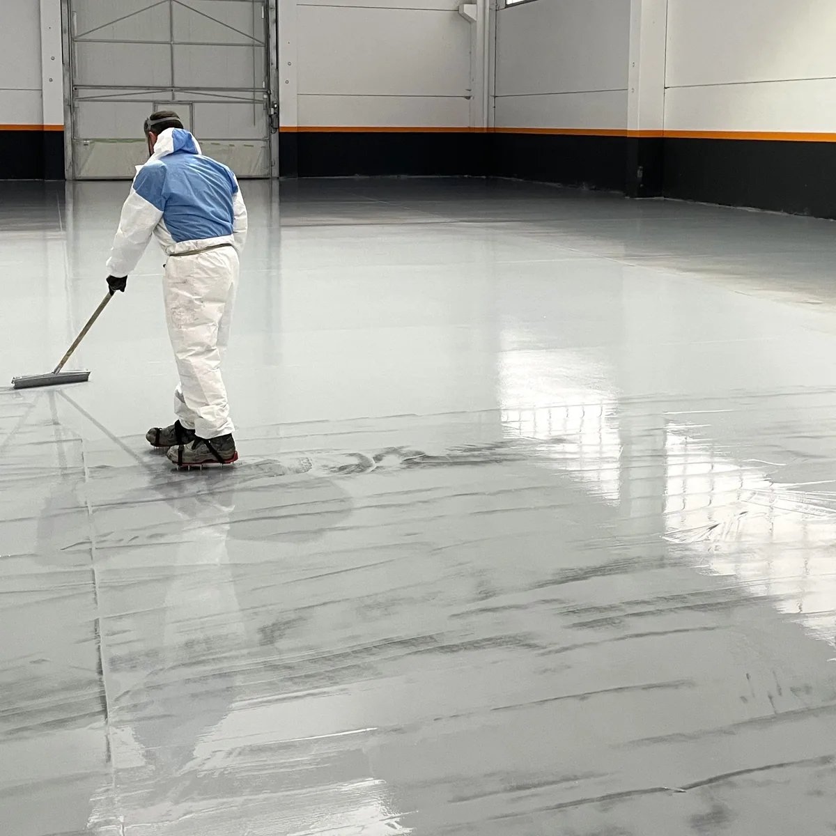 Applicator back-rolling grey EP Coat 100 in a factory bay, Galicia Applicator back-rolling grey EP Coat 100 in a factory bay, Galicia