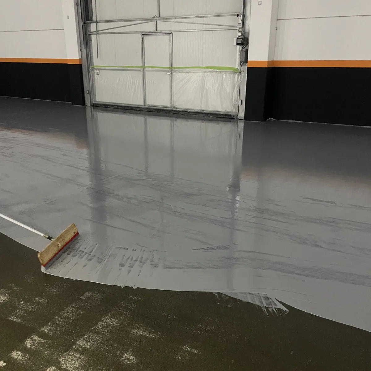 Wet epoxy edge near the factory door with a roller, Galicia Wet epoxy edge near the factory door with a roller, Galicia